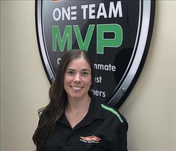 A girl standing in front of SERVPRO one team sign