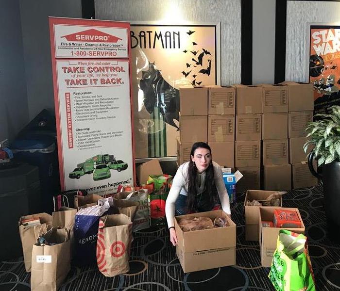 Girl packing boxes of food at a food drive