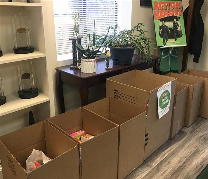 Boxes of food donations on the floor in an office 